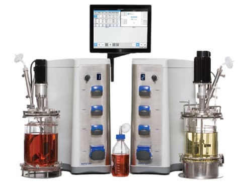 Benchtop bioreactor units with vessels and a touchscreen controller.